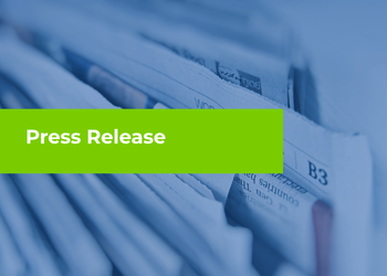 A close-up stack of newspapers with a bright green banner across the center that reads “Press Release.”